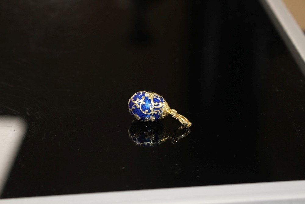 A modern 925 gilt white metal, blue enamel and diamond set egg shaped pendant, egg 20mm, gross weight 4.1 grams.